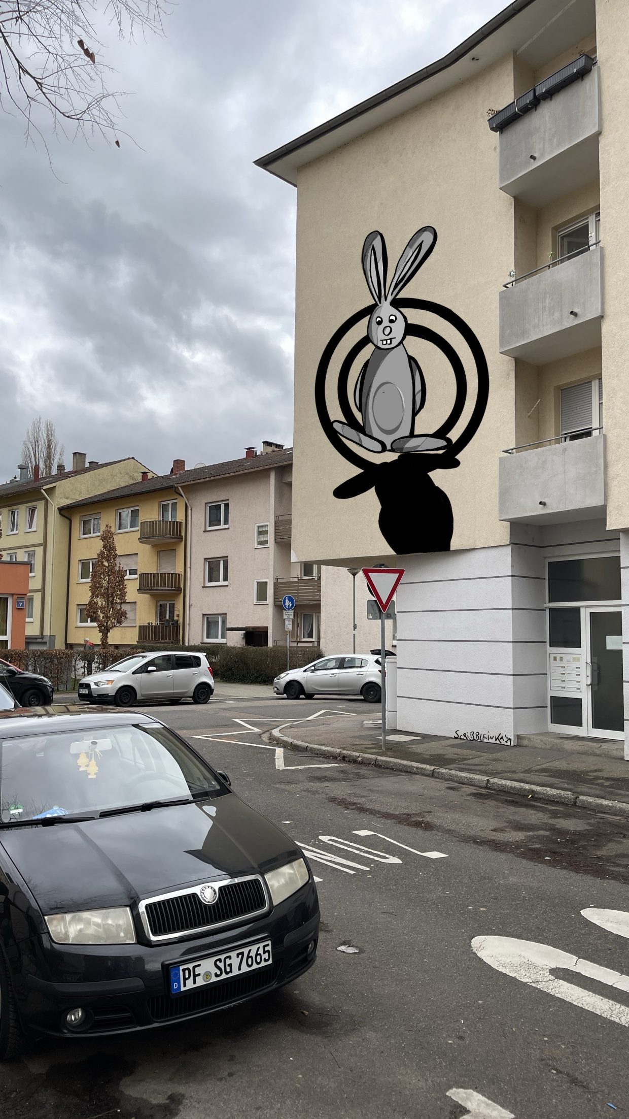 Außenwand eines Gebäudes in der Wörthstraße in Pforzheim. Zeigt ein Graffiti mit einem Hasen, der innerhalb von zwei Kreisen steht, vor seinen Füßen ein Schatten