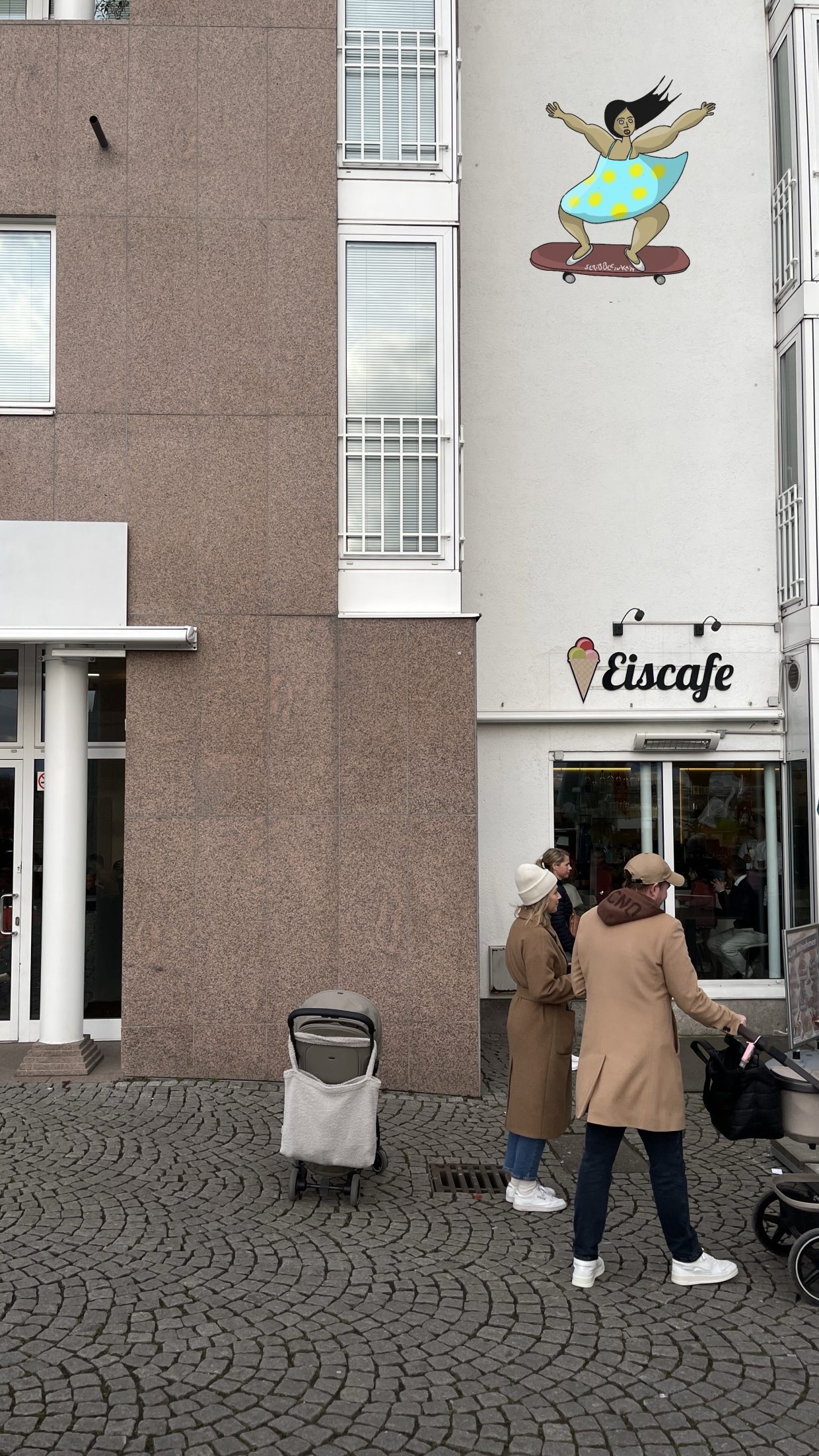 Eingang des Eiscafé Dante in Düsseldorf. Oberhalb des Eingangs findet sich das Gemälde einer skatenden Frau mit dunklem Haar, einem blauen Kleid mit gelben Punkten.